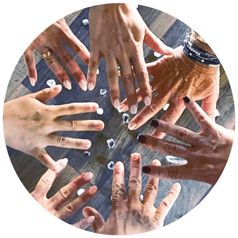 Diverse hands together in unity circle.